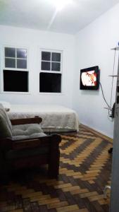 - un salon avec un lit, un canapé et des fenêtres dans l'établissement Sobrado Tranquilo Centro, à Porto Alegre