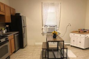 a kitchen with a table and a refrigerator and a window at Home away from Home! A place to focus and relax! in Cambridge