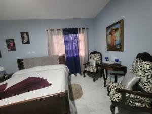 a bedroom with a bed and a table and chairs at Estancia Las Mercedes in San Felipe de Puerto Plata