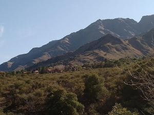 uma vista para uma montanha com uma casa num campo em La Gloria em Merlo