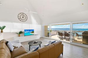 - un salon avec un canapé, une télévision et une table dans l'établissement Crows Nest 6 Teramby Road D Albora Marina, à Nelson Bay