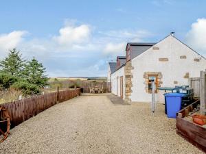 a barn conversion with a gravel driveway and a fence at The Barn in Lagg