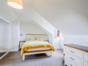 een slaapkamer met een bed met een gele deken bij The Barn in Lagg