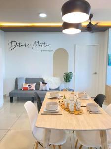 uma sala de jantar com uma mesa com cadeiras e um sofá em Breezy 2-10Pax Trefoil Setia City Shah Alam SiS Homestay em Shah Alam