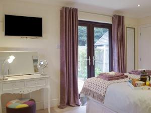 a bedroom with a bed and a desk and a window at Neyland Marina in Neyland