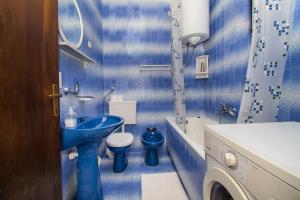 uma casa de banho azul com um lavatório e um WC em Apartments Ivan em Srima