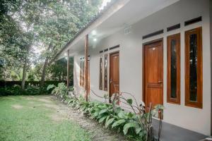 a white house with a door and some plants at Residences by RedDoorz near Taman Safari in Bogor