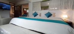 a bedroom with a large white bed with blue pillows at Runa Apartamentos in Cusco