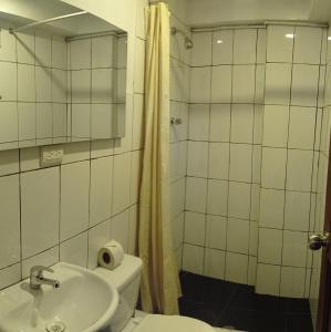 a bathroom with a toilet and a sink and a shower at Runa Apartamentos in Cusco