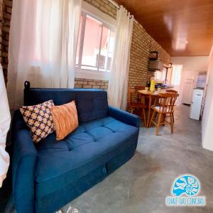 ein blaues Sofa im Wohnzimmer mit einem Tisch in der Unterkunft Chalé das Conchas in Pipa