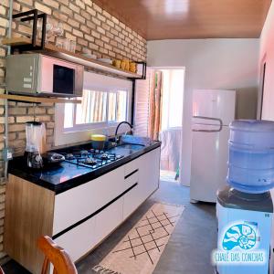 eine Küche mit einem Herd und einem Kühlschrank in der Unterkunft Chalé das Conchas in Pipa