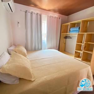 Schlafzimmer mit einem großen weißen Bett und einem Fenster in der Unterkunft Chalé das Conchas in Pipa