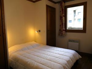 a bedroom with a white bed with a window at Appartement Aussois, 4 pièces, 6 personnes - FR-1-508-279 in Aussois