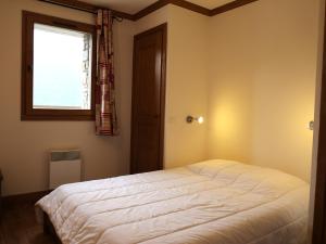 Un dormitorio con una gran cama blanca y una ventana en Appartement Aussois, 3 pièces, 6 personnes - FR-1-508-278, en Aussois