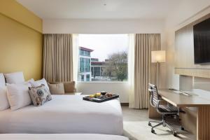 a hotel room with a bed and a desk at Novotel Auckland Ellerslie in Auckland +62 photos