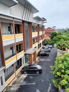 um parque de estacionamento com carros estacionados em frente a um edifício em Preme Apartment @maejo em Ban Pa Lan