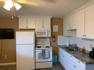 uma cozinha com um frigorífico branco e um lavatório em Couples getaway em Bullhead City