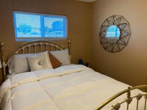 1 dormitorio con cama blanca y espejo en la pared en Couples getaway, en Bullhead City