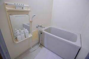 a bathroom with a bath tub and a sink at 寄道アパート高松東インターチェンジ店201 最大5名1戸貸切 無料駐車場 in Kawashima