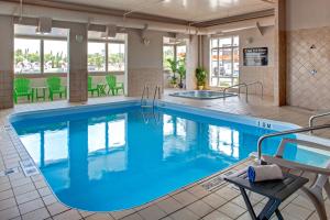 a pool with blue water in a hotel room at Super 8 by Wyndham Brandon MB in Brandon