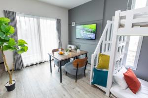 a dining room with a table and a bunk bed at The Base Sapporo Susukino in Sapporo