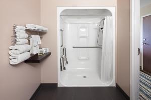 a bathroom with a shower with a white refrigerator at Super 8 by Wyndham Brandon MB in Brandon