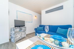 een woonkamer met een blauwe bank en een tv bij Beach House Tenerife in Costa Del Silencio