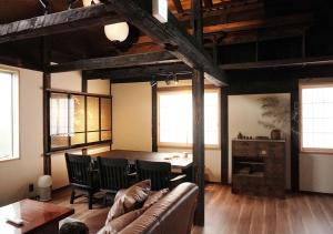 een woonkamer met een bank en een tafel bij [貸切り] 220㎡ 月のワルツ 108年前の高級古民家 in Komoro