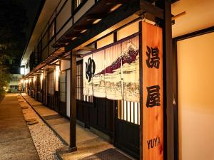 a building with signs on the side of it at night at Hakone Onsen Yuyado Yamanoshou in Hakone