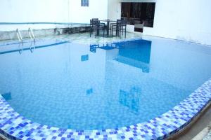 a large swimming pool with a table in the middle at Vang Vieng Freedom Star's Hotel in Vang Vieng