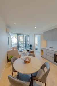 una sala de estar con una mesa y sillas en Realm Apartments by CLLIX, en Adelaida