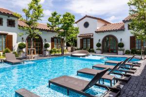 a swimming pool with chairs and a house at Villa Seville in Hua Hin