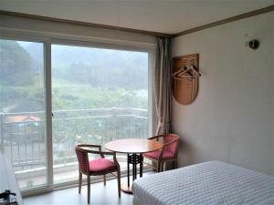 a bedroom with a table and chairs and a window at Galcheon Family Resort in Yangyang +4 photos