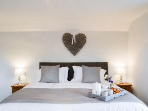 a bedroom with a bed with a heart plaque on the wall at Hillside Cottage in Hanmer