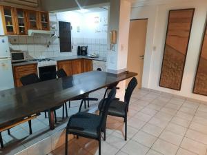 a kitchen with a large wooden table and chairs at Complejo las Palmeras II in Mendoza