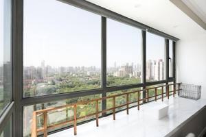 a room with large windows with a view of the city at Xujiahui park 2BR Apt in Shanghai