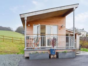 a small wooden house with a large balcony at Ty Nant - Uk32239 in Lower Chapel