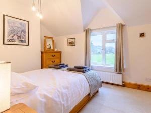 a bedroom with a large bed and a window at Lambton Cottage in Grosmont