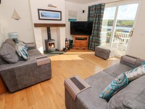 a living room with two couches and a fireplace at Pickleridge View in Haverfordwest
