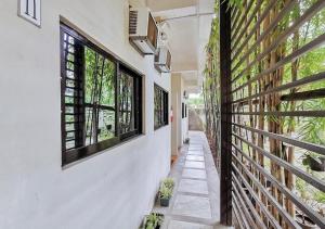 a corridor of a house with windows and plants at RedDoorz near KCC Mall Gensan in General Santos