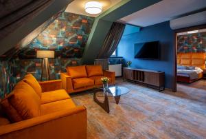 a living room with a couch and a tv at Hotel Styl 70 in Pszczyna