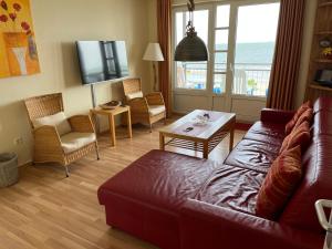 uma sala de estar com um sofá e uma mesa em Nordland Appartements - Wohnung Lolland em Wyk auf Föhr