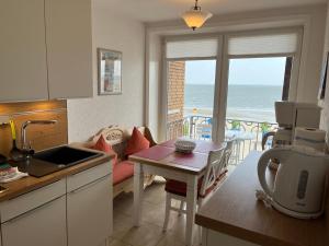 uma cozinha e sala de estar com vista para o oceano em Nordland Appartements - Wohnung Lolland em Wyk auf Föhr