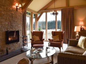 a living room with a couch and chairs and a fireplace at Mill Of Burncrook in Glenlivet
