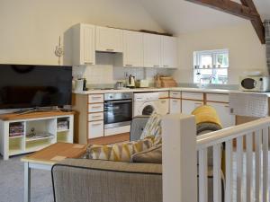 a living room with a couch and a kitchen at Moortown in Chulmleigh