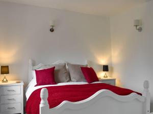 a bedroom with a white bed with red pillows at Moortown in Chulmleigh