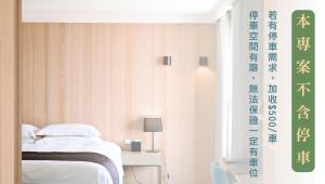 a bedroom with a bed and a table with a lamp at Gogo Hotel in Taichung