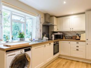 a kitchen with white cabinets and a dishwasher at Hampsfell Cottage - Uk1518 in Grange Over Sands