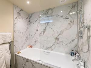 a bathroom with a shower and a white tub at Hampsfell Cottage - Uk1518 in Grange Over Sands