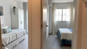 um quarto com uma cama e uma janela e uma janela em Moderno piso de 3 dormitorios en la playa de Rincon de la Victoria Malaga em Rincón de la Victoria
